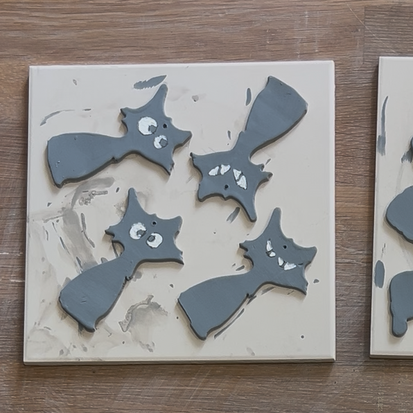 Vier fertige Halloween-Katzen aus Ton mit individuell aufgemalten Spuk- und Gaga-Augen sowie kleinen Löchern zum Aufhängen als Keramik-Deko.